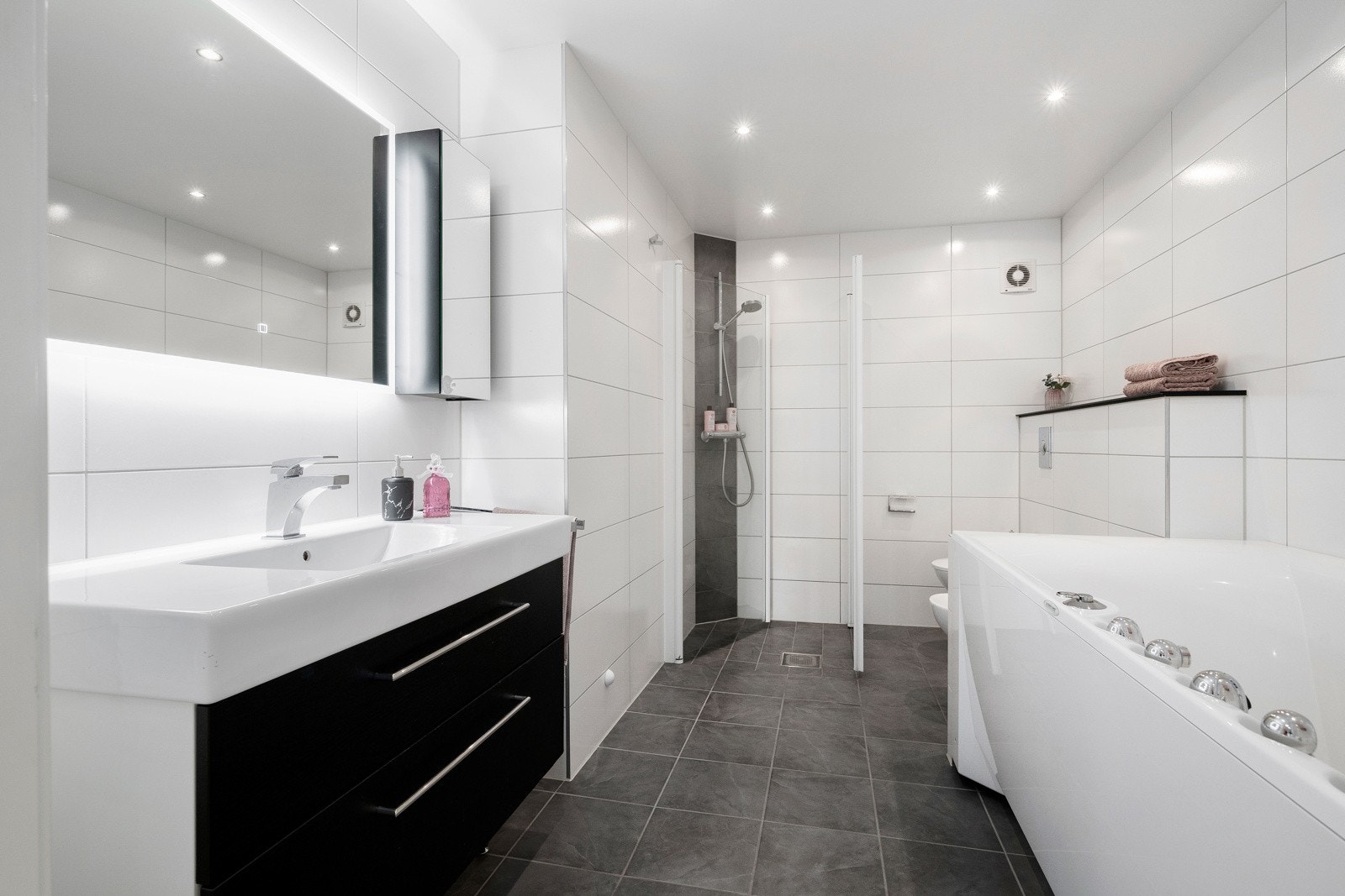 Oppusset baderom med flislagte overflater og behagelig varme i gulvet. Deilig boblebad for ekstra velvære. Galleribilde