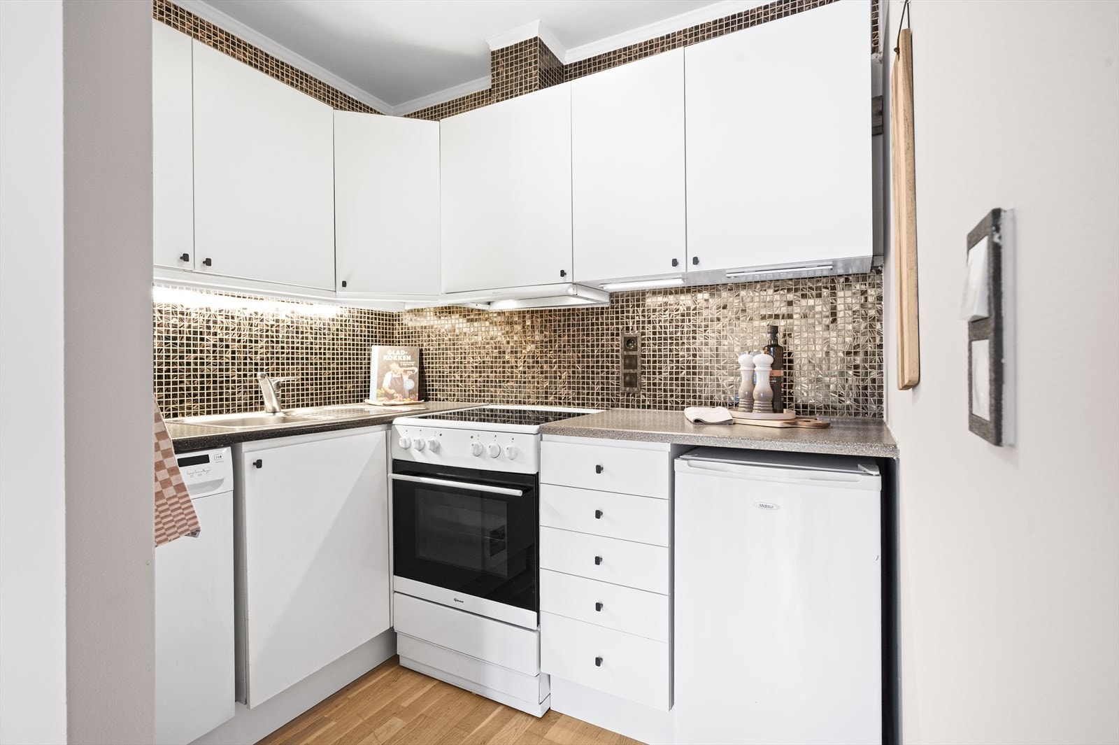 Praktisk kjøkken med glatte fronter og laminat benkeplate. Galleribilde