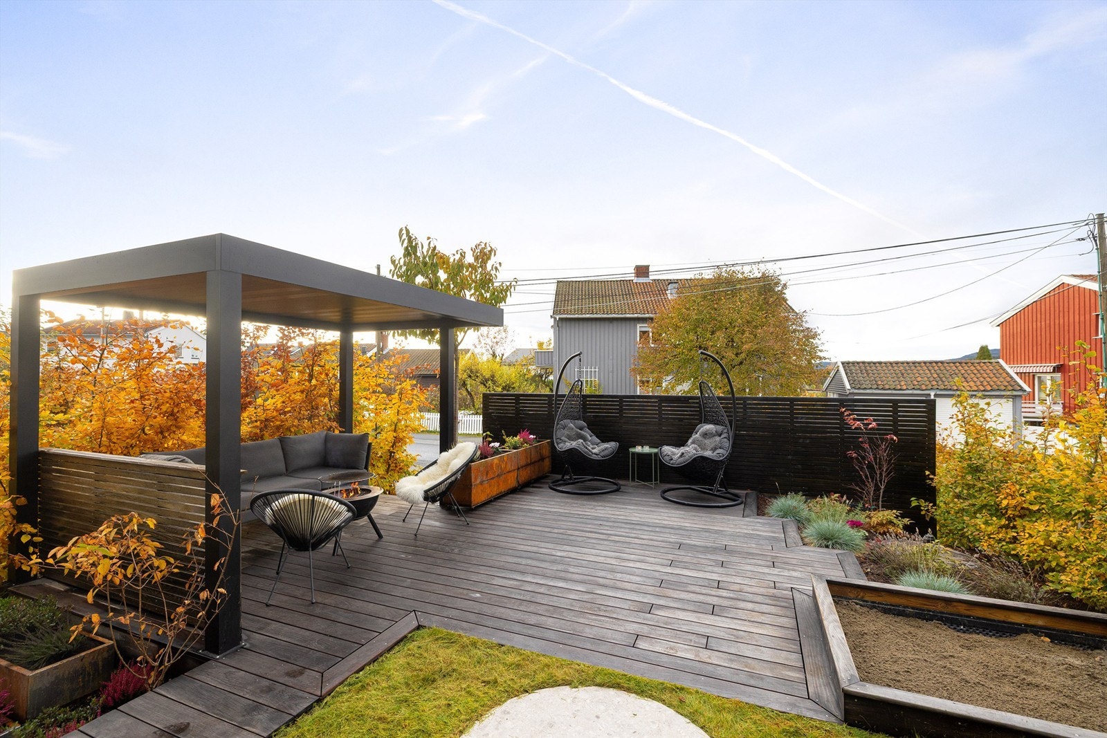 Sandkasse for de minste og blomsterkasser i cortenstål til de voksne. Alle generasjoner vil finne seg til rette i denne hagen! Galleribilde