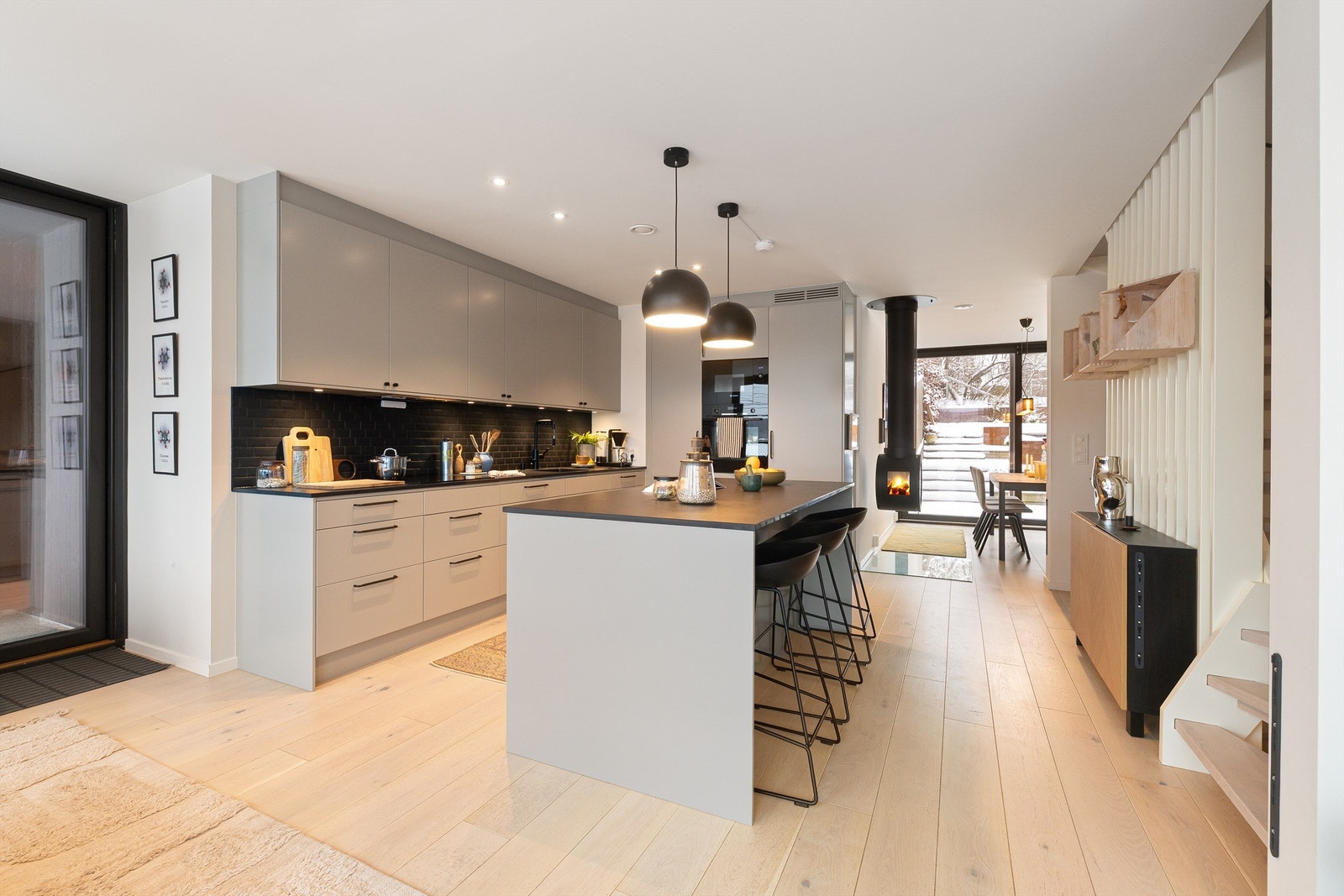 Stilren kjøkkeninnredning fra Drømmekjøkkenet. Her finner du rikelig med oppbevaringsplass og en fin kjøkkenøy som både gir arbeidsplass og et hyggelig sted til frokosten. Galleribilde