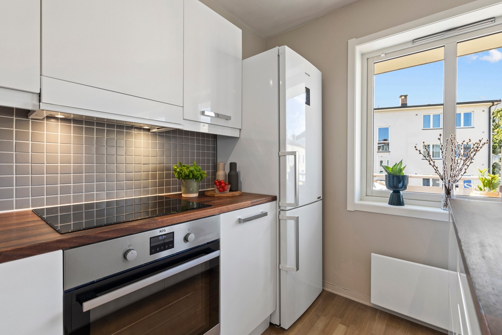 Kjøkkenet har høyglans innredning, heltre benkeplate og integrerte hvitevarer. Galleribilde