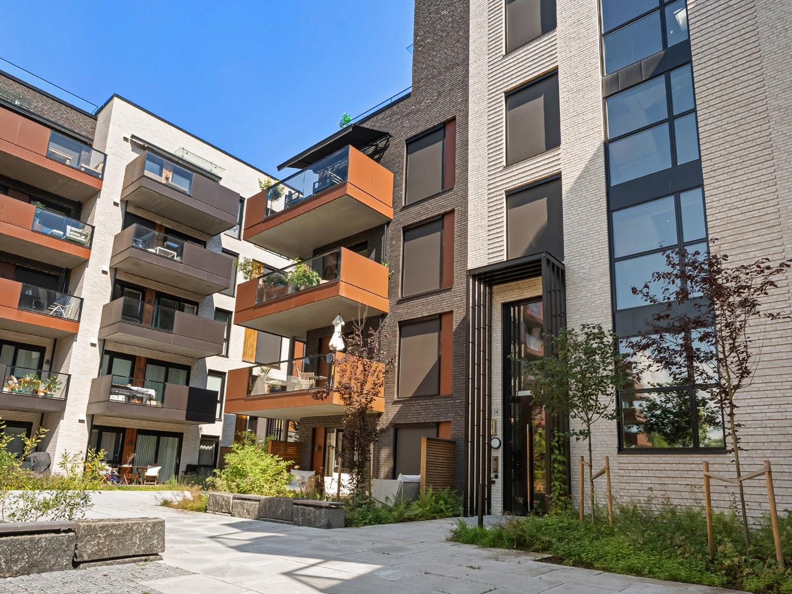 Inngangspartiet har høye søyler og pent opparbeidet grøntareal - et representativt møte med både bygget og bomiljøet. Her får du en smak av kvalitet og ro allerede før du trer inn i leiligheten. Galleribilde