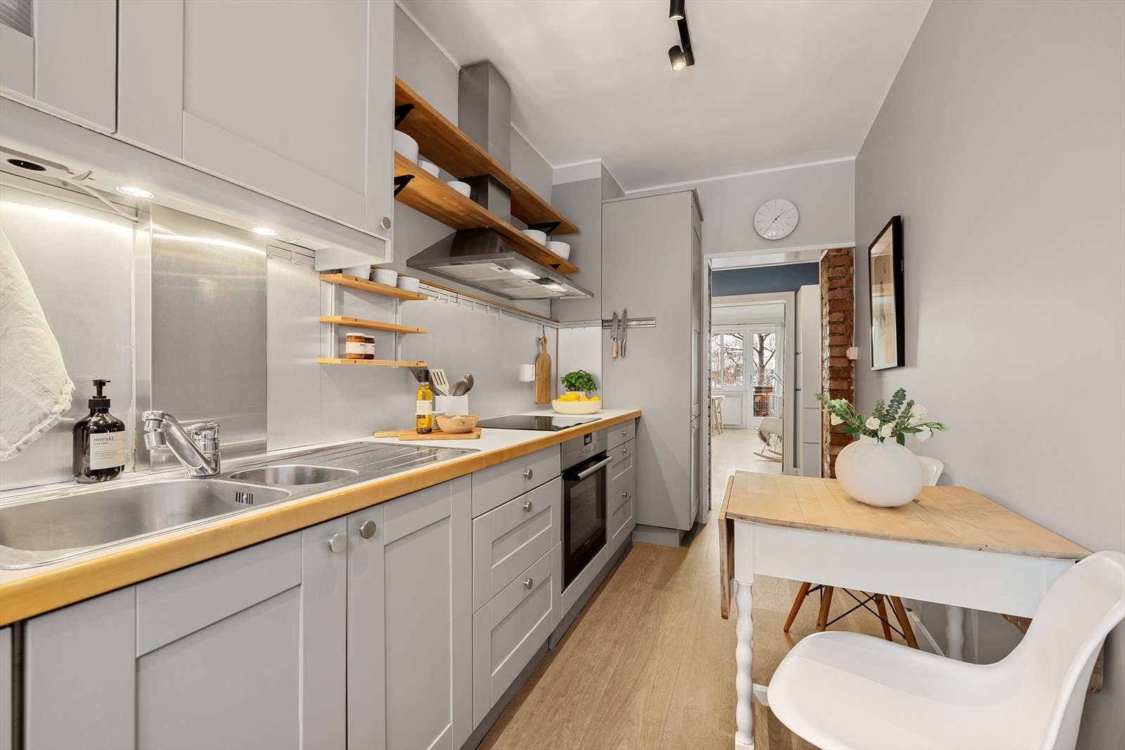 Innredningen består av profilerte fronter med enkelte glassfronter i overskap og laminat benkeplate med nedfelt kum i rustfritt stål. Det er stålplate montert på vegg over benkeskap. Galleribilde