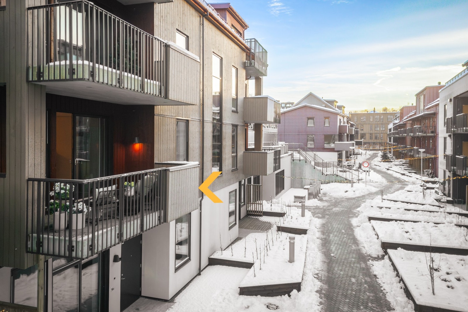 Sameiet har pent opparbeidet tomt med nydelig bilfritt tun mellom bygningene - Leiligheten markert med pil Galleribilde