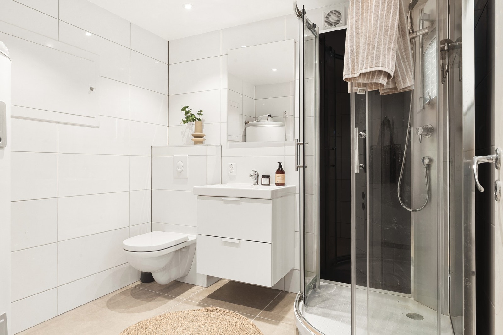 Helfliset bad i 1.etasje på 5 kvm oppusset i 2018-2020 med innfelte downlights i tak, varmekabler i gulv og opplegg for vaskemaskin. Galleribilde