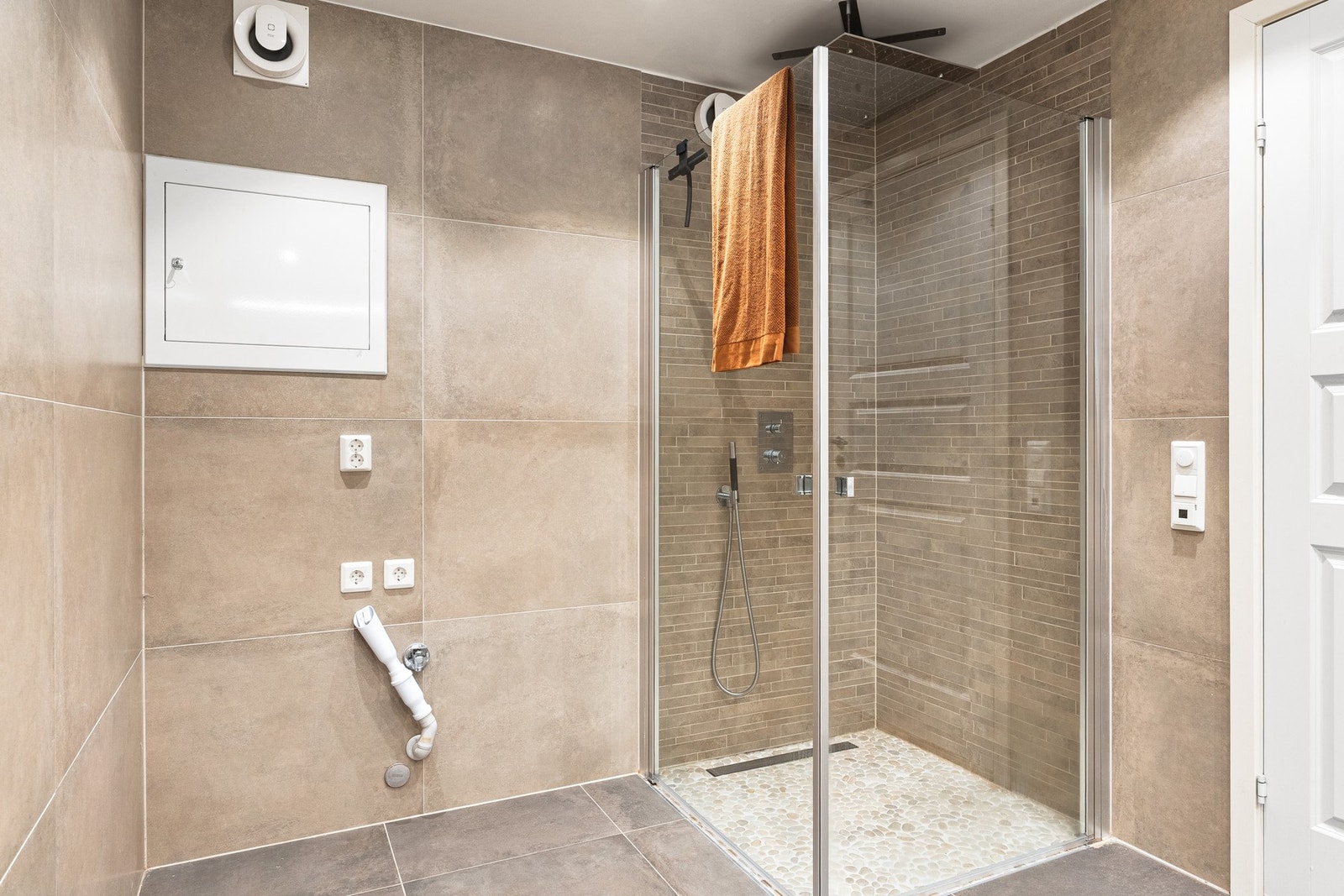 Badet er innredet med dusj med glassvegger, vegghengt toalett, baderomsinnredning og opplegg for vaskemaskin. Galleribilde