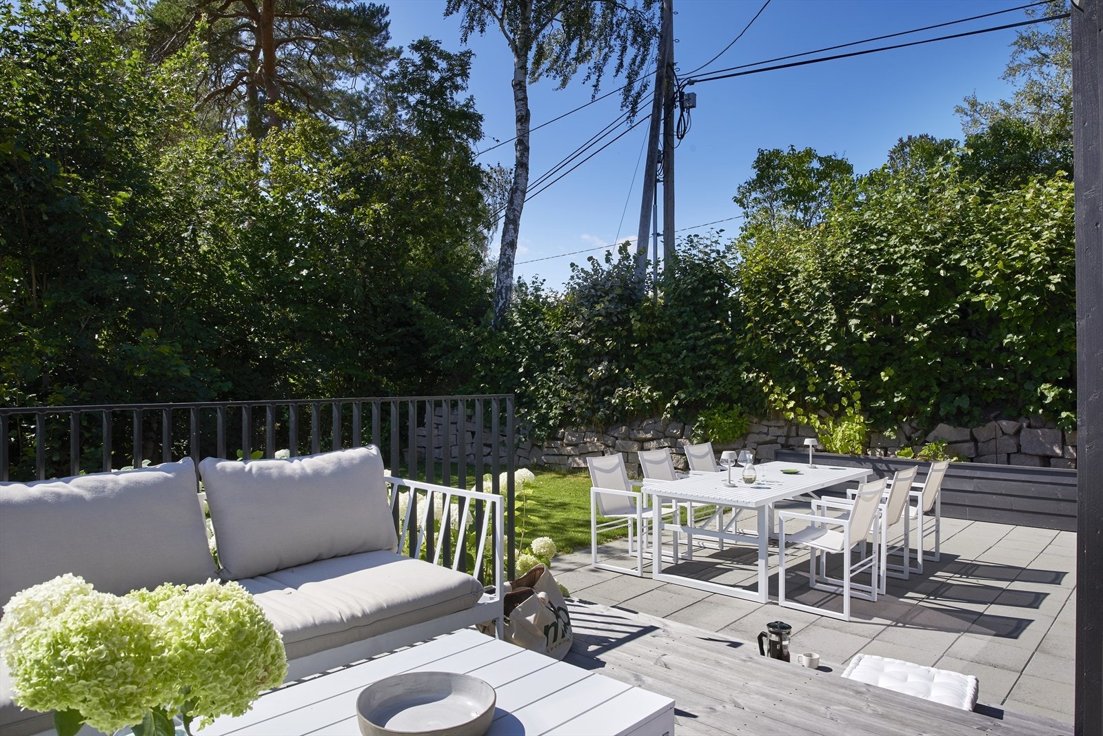 Fra terrassen er det videre tilgang til hellelagt platting, med plass til spisebord, grill m.m. Galleribilde