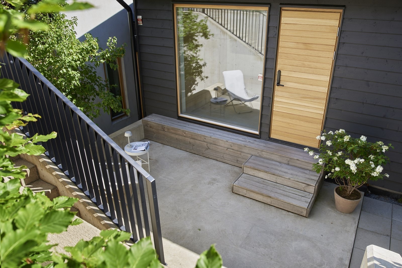 Hyggelig uteplass også ved inngangspartiet, innrammet av hyggelig beplanting Galleribilde