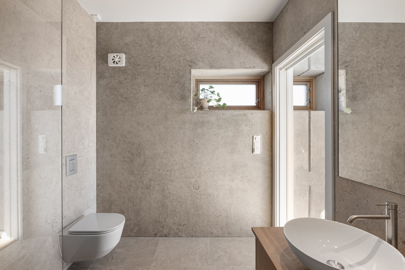 Stort og lekkert en-suite-bad, med delikate og moderne fliser på vegger, og kalkstein fra Lenngren Natursten på gulv Galleribilde