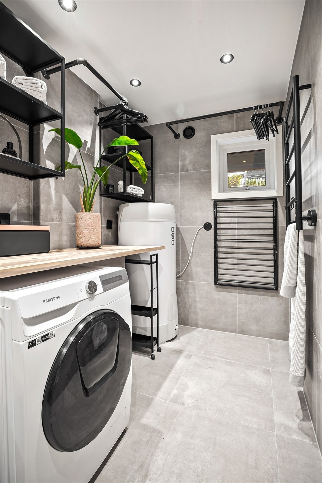 Badet har dusjhjørne med regnfallsdusj og opplegg for vaskemaskin Galleribilde