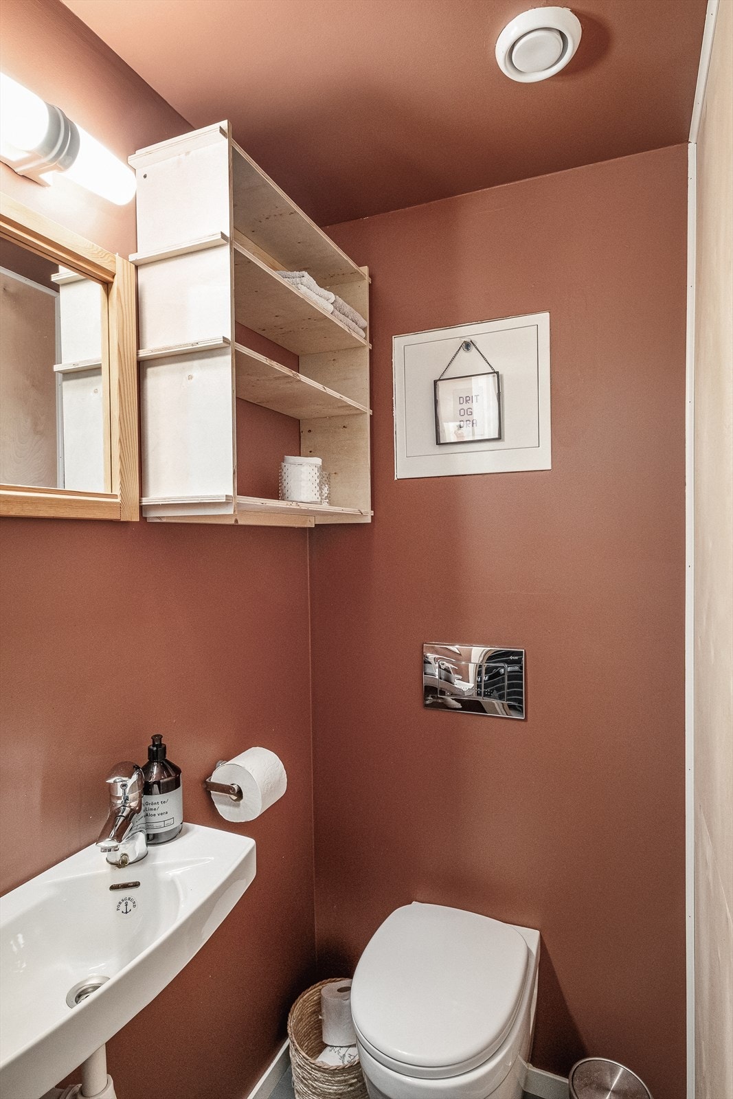 Toalettrom med beleggfliser på gulv, malte flater på vegger. Sanitærutstyr er vegghengt toalett og servant. Galleribilde