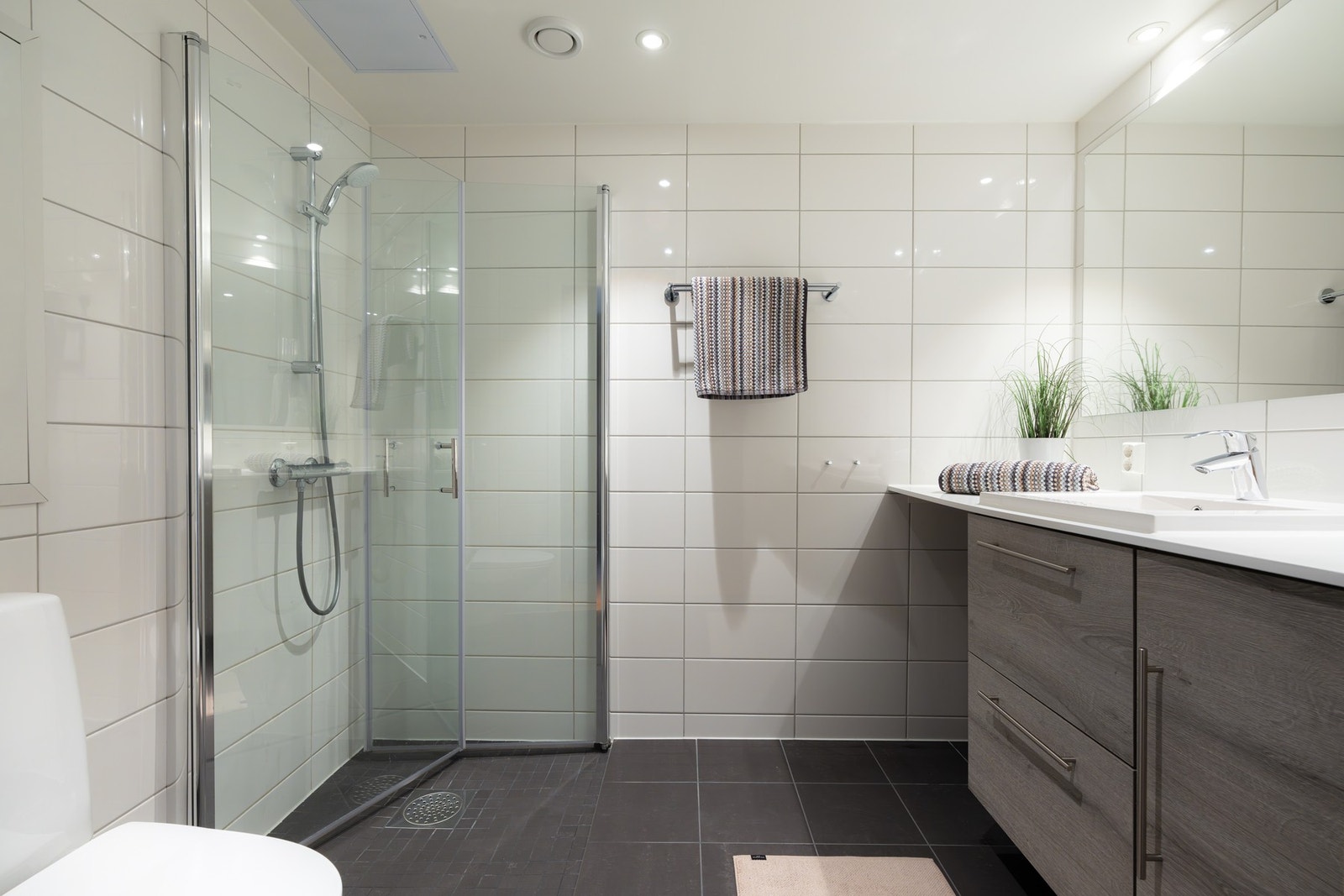 Fra oppholdsrommet har du tilgang til ett av boligens to baderom. Lyst, flislagt med varme i gulv og downlights i himling. Galleribilde