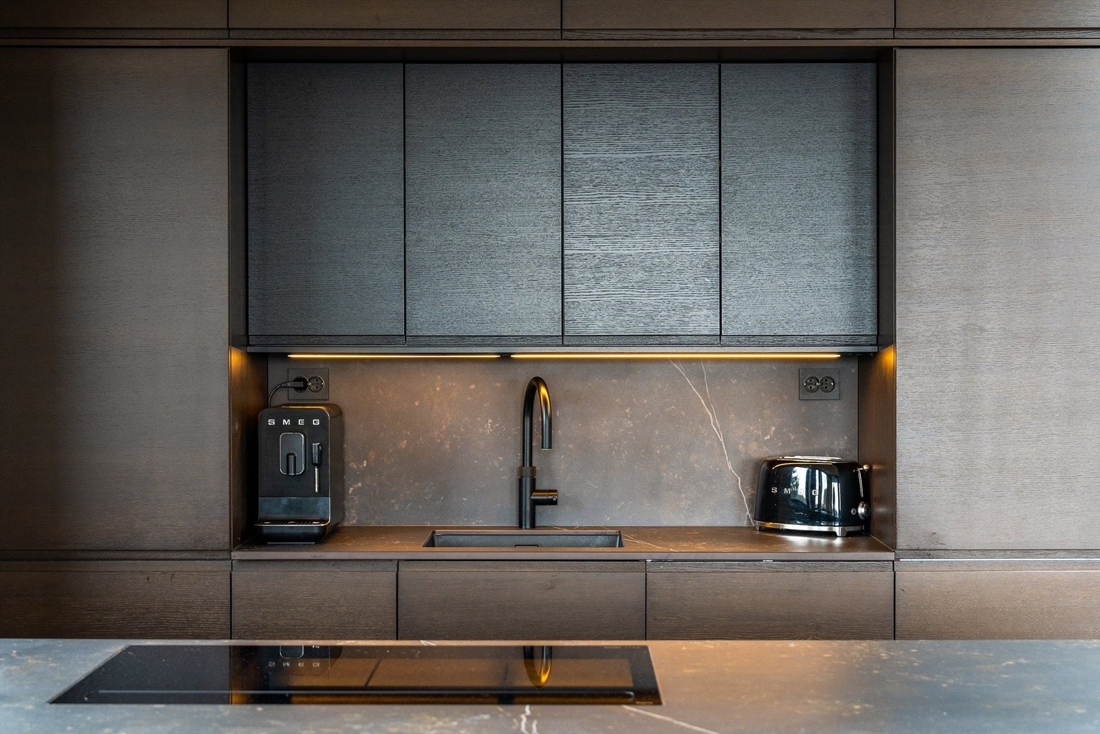 Kjøkkenets design er stilrent og eksklusivt. Kjøkkenøya fungerer som en naturlig romdeler, og har i tillegg godt med oppbevaringsplass. Galleribilde