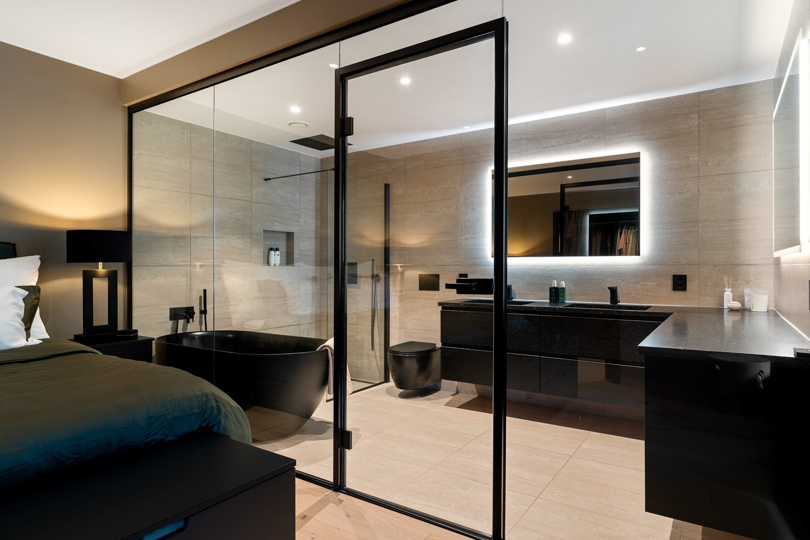 Glassveggen utgjør et usynlig skille mellom de to rommene, og lar samtidig lyset bevege seg fritt. Galleribilde