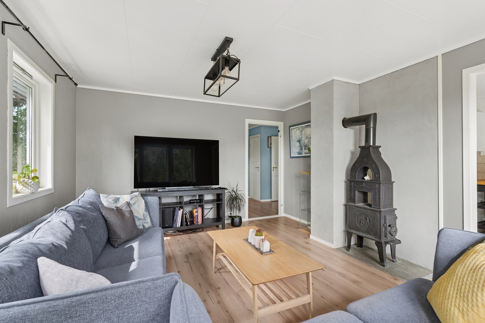 Stuen er romslig og lys, med peis som gir ekstra hygge - og gode møbleringsmuligheter Galleribilde