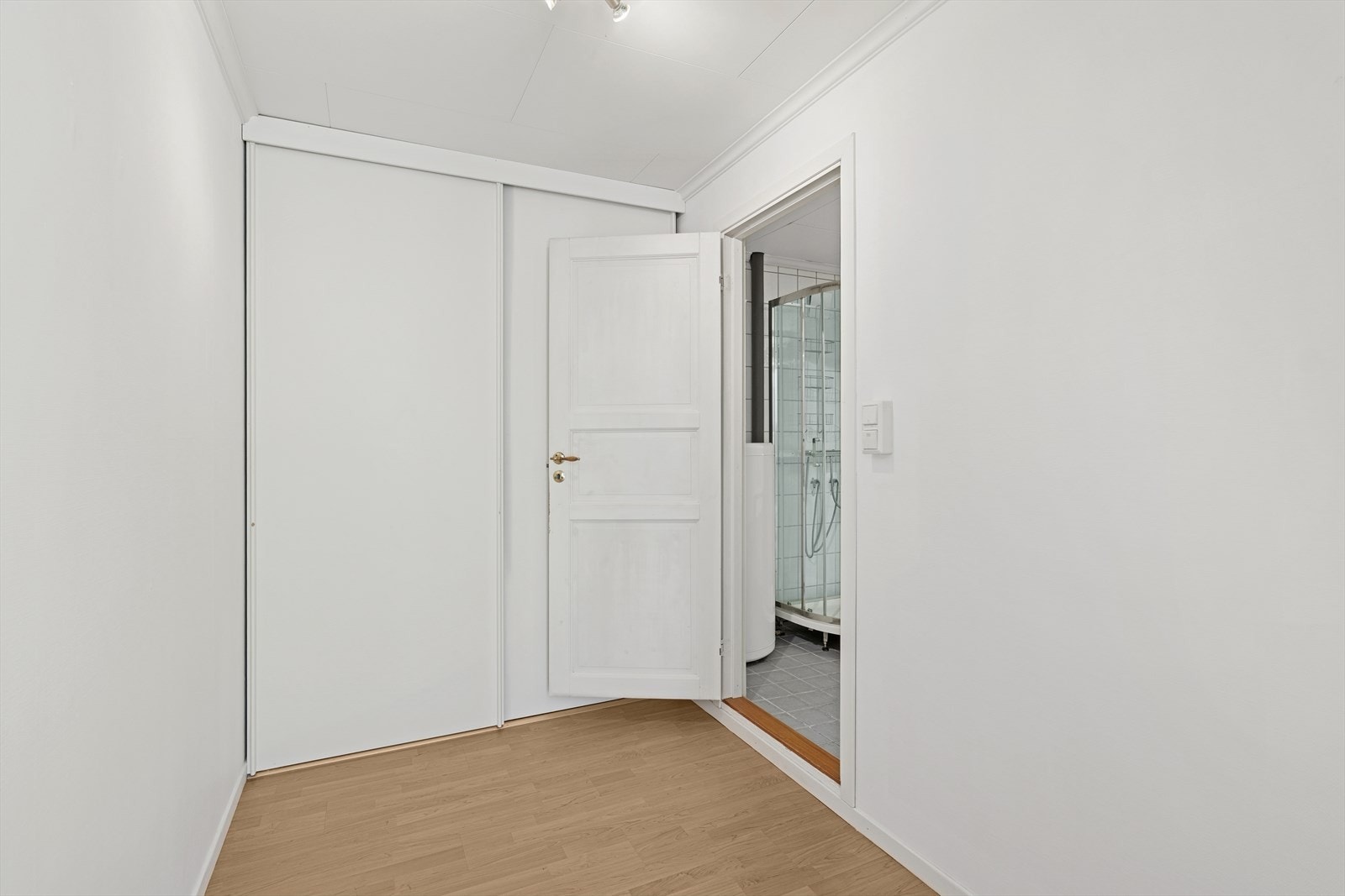 Skyvedørsgarderobe i gangen gir praktisk oppbevaring, med direkte adkomst til baderommet Galleribilde