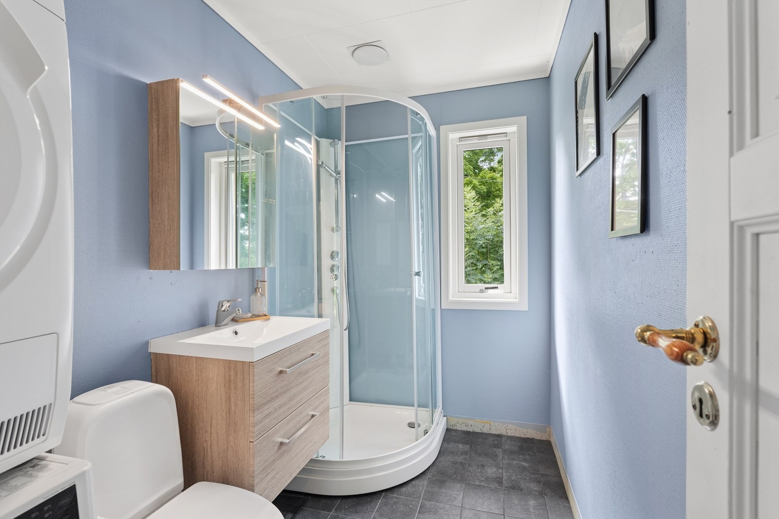 Baderommet er fra byggeåret. Det er oppgradert med ny servant, speil med skap og dusjkabinett Galleribilde