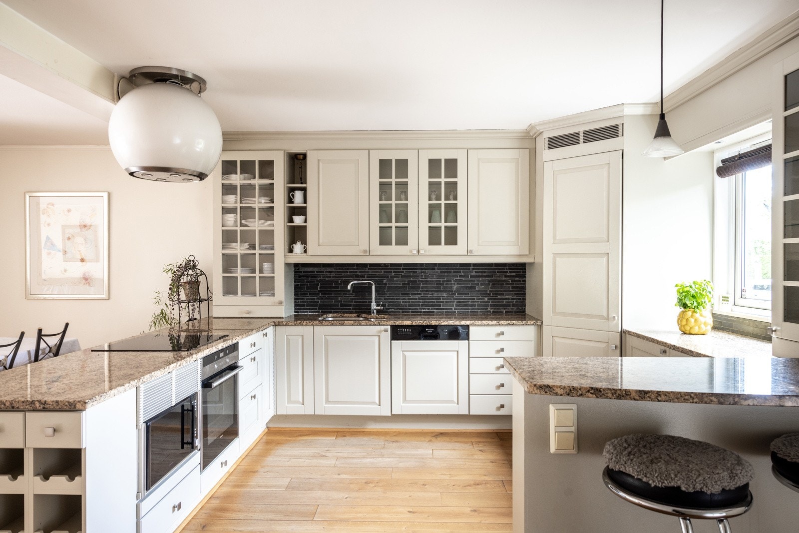 Innbydende og praktisk kjøkken med innredning bestående av glatte og profilerte fronter, med en tidløs og klassisk stil. Galleribilde