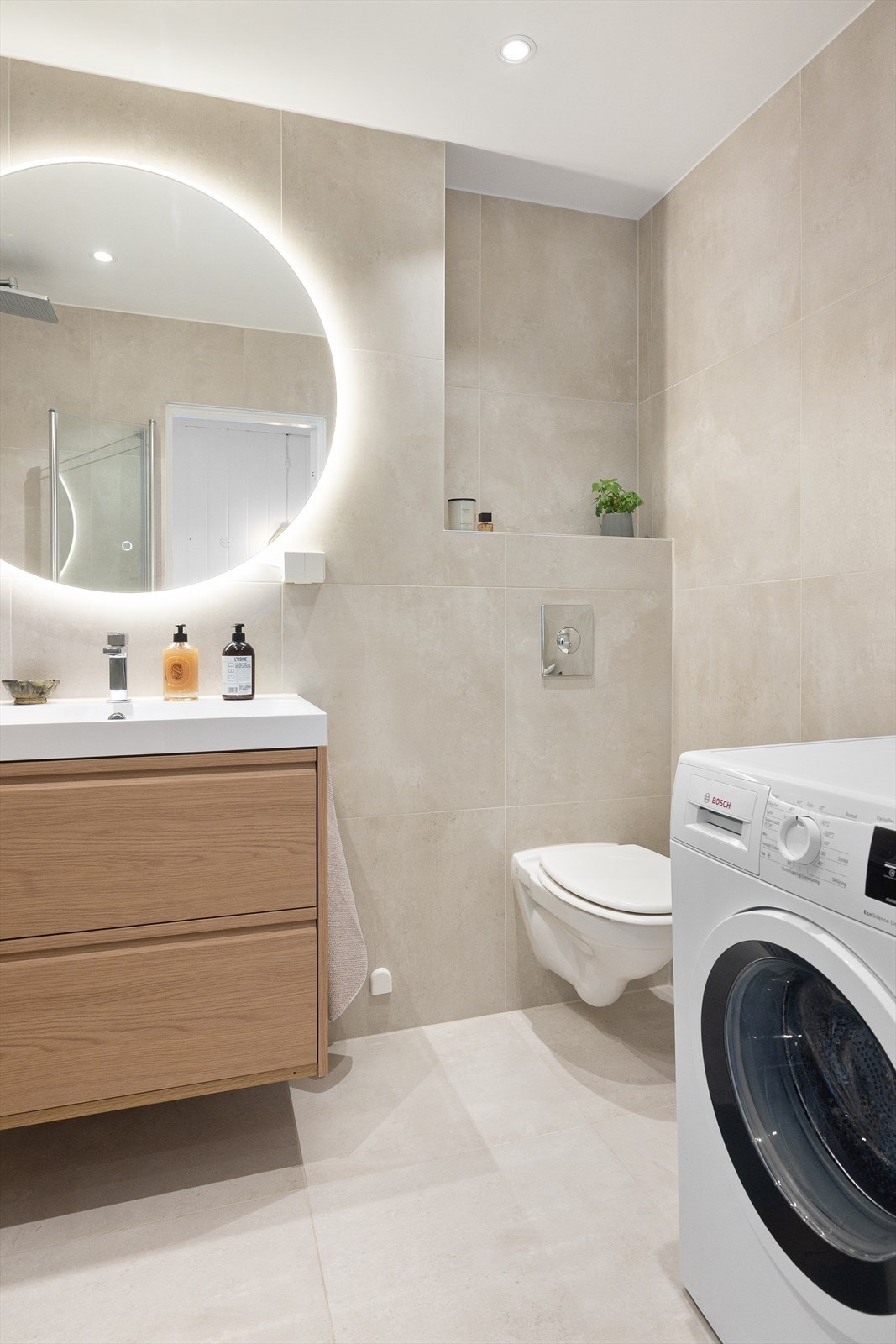 Her er det downlights i himling, speil med lys, servant med oppbevaring i underskap, dusj med innfellbare glassdører, samt opplegg til vaskemaskin. Galleribilde