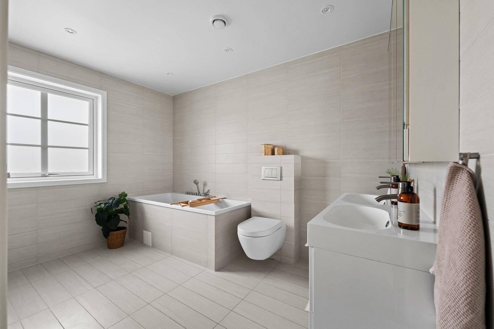 Det elegante hovedbadet har innebygget badekar, vegghengt toalett og dobbel servant med underskap og speilskap. Galleribilde