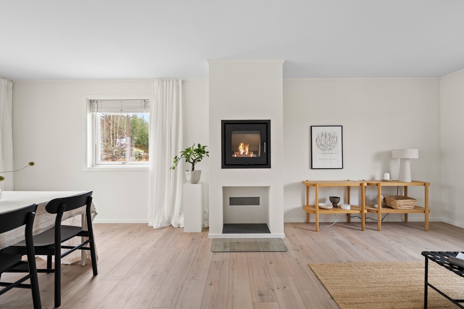 Boligen har også en stilfull peis som fungerer som et stemningsskapende midtpunkt, samtidig som den skaper et elegant skille mellom sonene. Galleribilde