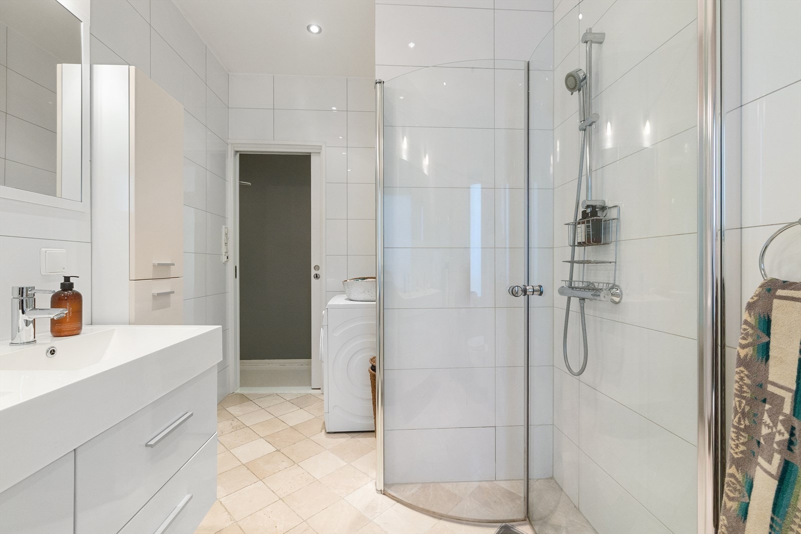 Rommet er utstyrt med veggmontert toalett, dusjhjørne med innfellbare glassdører og baderomsinnredning med skuffer, speil og dobbel servant hvor begge har ettgrepsblandebatteri fra Tapwell. Galleribilde