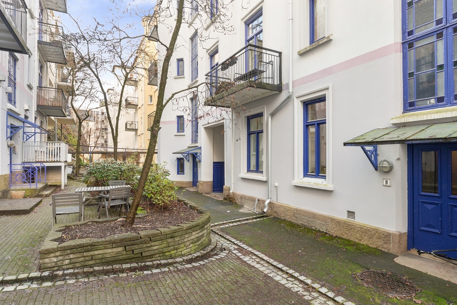 Skjermet bakgård med sittegrupper og beplantning. Galleribilde