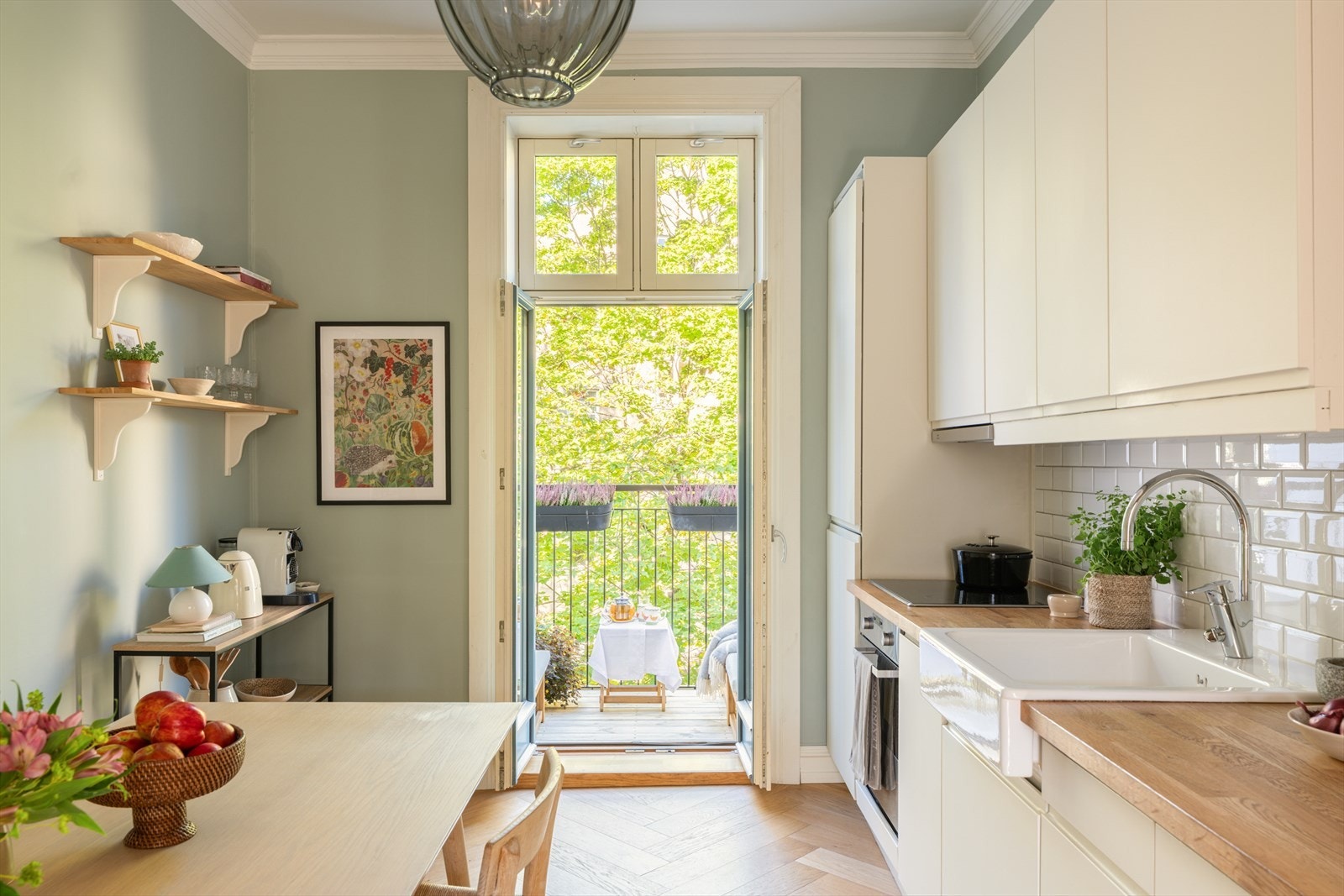 Pen og moderne kjøkkeninnredning med slette fronter, benkeplate i tre, fliser mellom over- og underskap og integrerte hvitevarer. Galleribilde