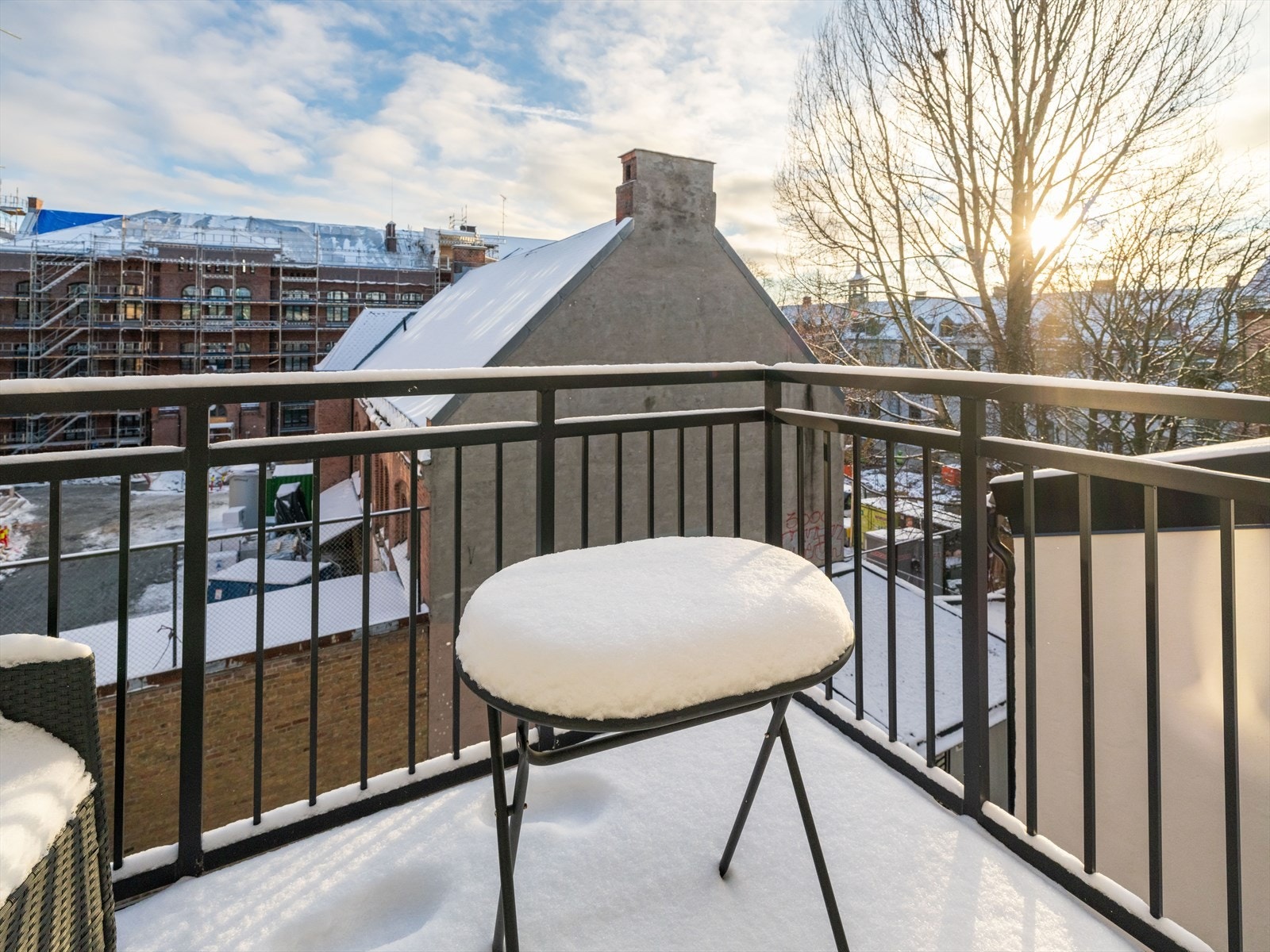 Utsikt fra balkongen gir et godt overblikk over nærområdet, med sollys som skinner inn. Galleribilde