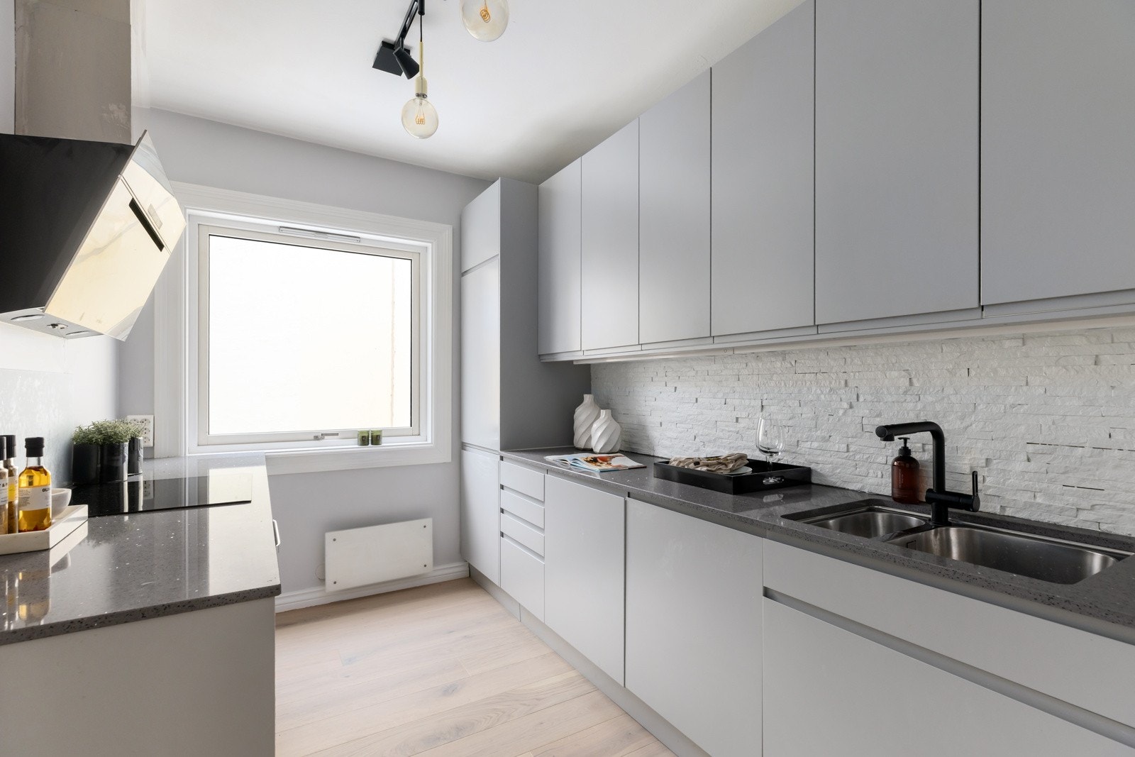 Kjøkkenet ligger i eget rom med østvendte vinduer mot bakgården og har direkte adkomst til både stue/spisestue og det ene soverommet. Innredningen ble fornyet i 2019 og er holdt i et stilrent design, plassert parallelt langs to sider av rommet. Galleribilde