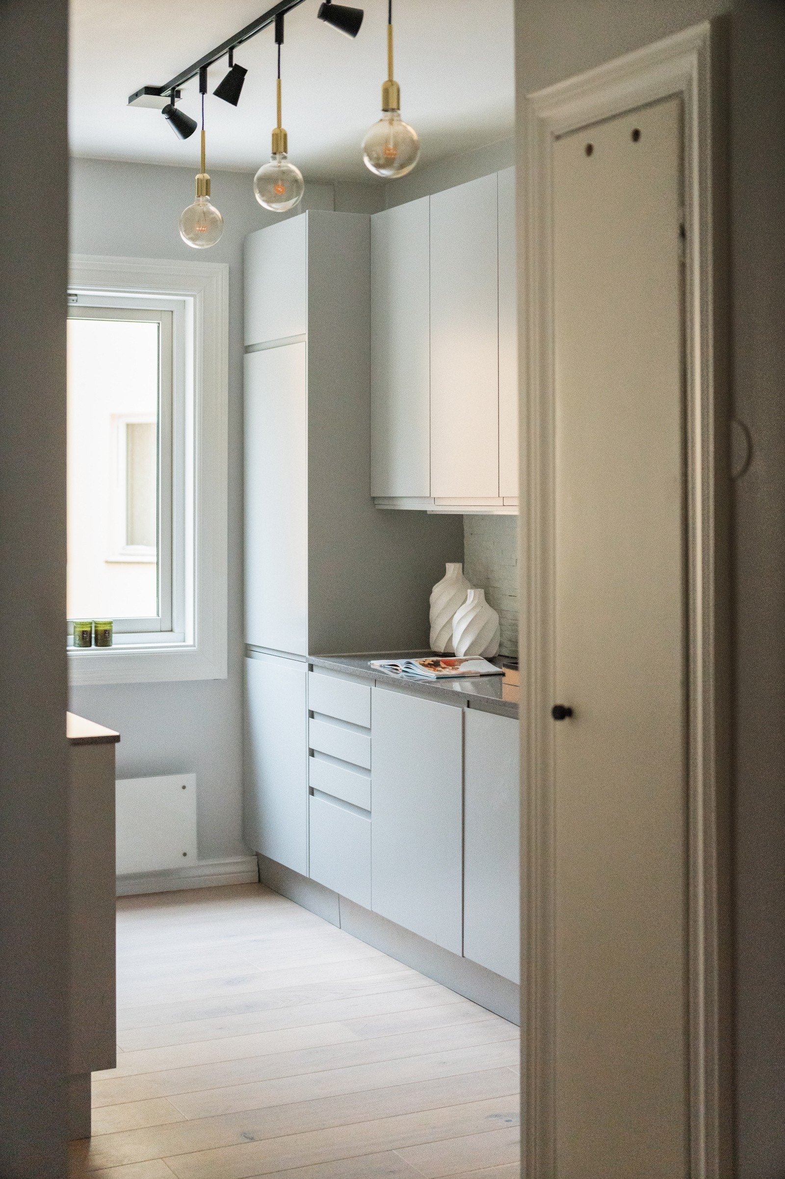 Ved inngangen til kjøkkenet finnes et plassbygd, originalt skap i veggen. Enstavs eikeparkett fra 2025 er lagt sømløst mellom kjøkken, stue/spisestue og gang/entré. Galleribilde