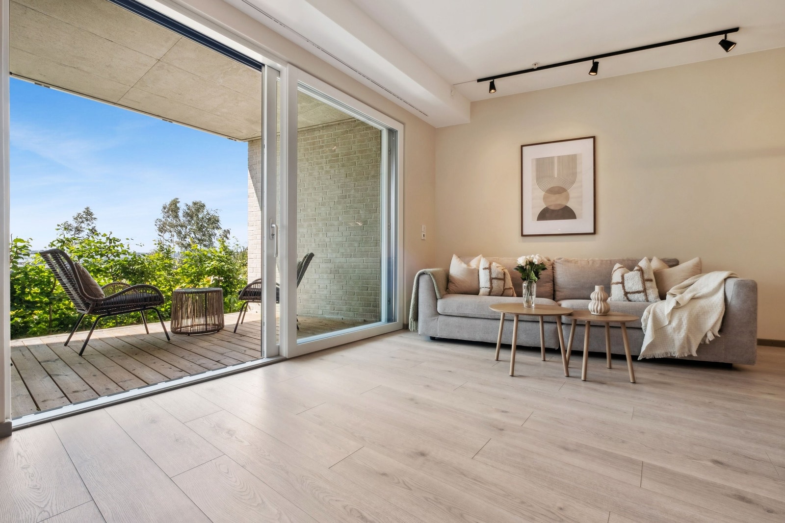 Fra sofakroken kan du nyte utsikten gjennom de store skyvedørene som åpner opp mot terrasse og uteområder. Galleribilde