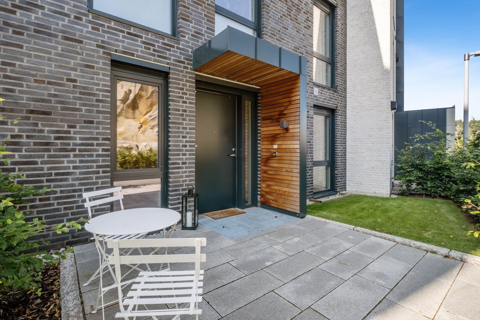 Eget inngangsparti med plass til et lite bord og to stoler - perfekt for morgenkaffen. Den lille hageflekken gir ett grønt og hyggelig preg. Galleribilde