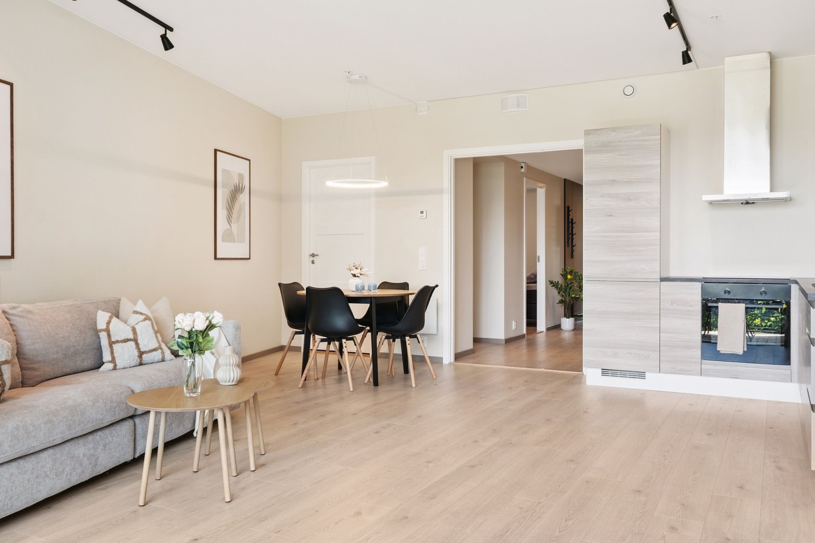 Åpen stue- og kjøkkenløsning med plass til både sofakrok og spisebord - her får du en lun og behagelig atmosfære året rundt takket være vannbåren gulvvarme i hele leiligheten. Galleribilde