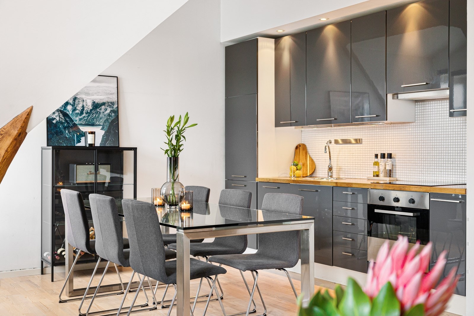 Et pent og funksjonelt kjøkken med gjennomført og smakfull innredning. Innredningen fra 2012 har glatte fronter, heltre benkeplate med integrert oppvaskkum og flislagt vegg over benkeplaten. Galleribilde