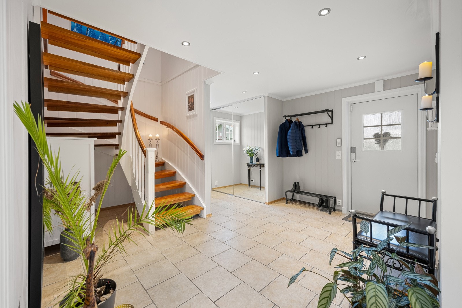 Det er bygget inn en praktisk skyvedørsgarderobe som gir gode oppbevaringsmuligheter, og ytterdøren er utstyrt med kodelås - en funksjonell og trygg løsning som passer perfekt for en aktiv familiehverdag. Galleribilde