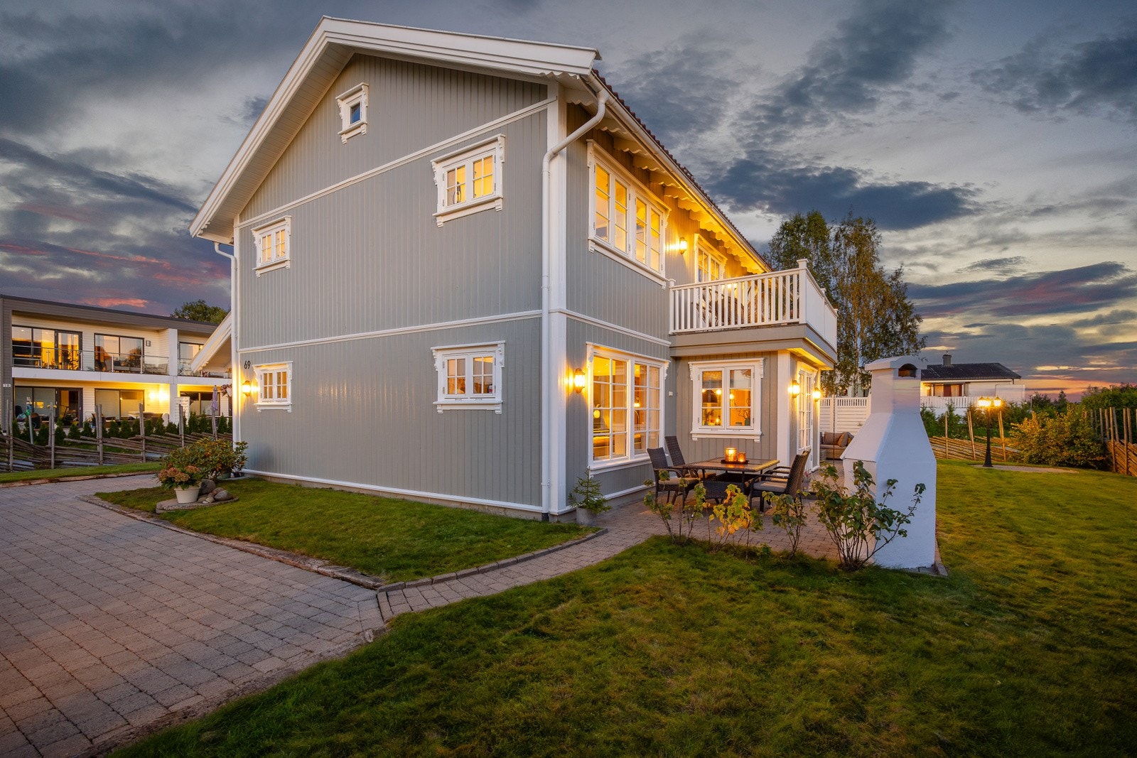 Velstelt uteområde med blomsterbed, plen og oppmurt utepeis - perfekt for sosiale sammenkomster. Galleribilde