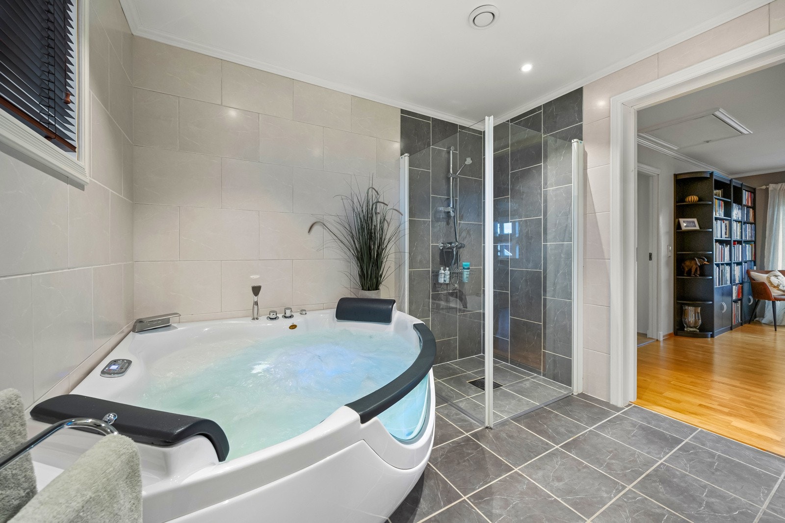 Videre har badet et vegghengt toalett, separat dusjhjørne med innfellbare glassdører og et stort boblebadekar. Galleribilde