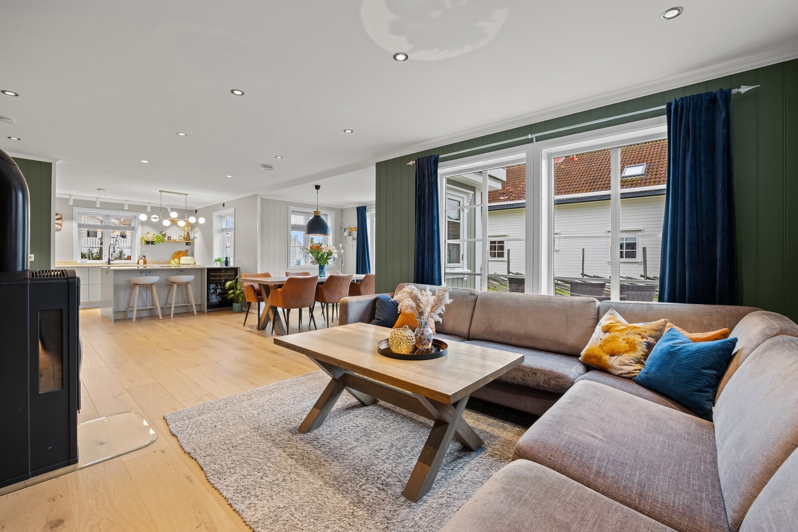 Den åpne stuen fremstår som svært innbydende med delikate, moderne fargevalg og en gjennomført stil. Store vindusflater i flere himmelretninger slipper inn rikelig med dagslys og skaper en lys og luftig romfølelse gjennom hele dagen. Galleribilde