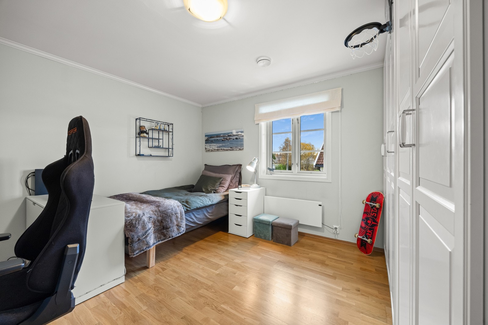 Soverom 4 er et stort og lyst rom med parkett på gulv, lyse overflater og store vinduer som slipper inn godt med dagslys. Langs den ene langveggen er det montert rikelig med garderobeskap, som gir svært gode oppbevaringsmuligheter. Galleribilde