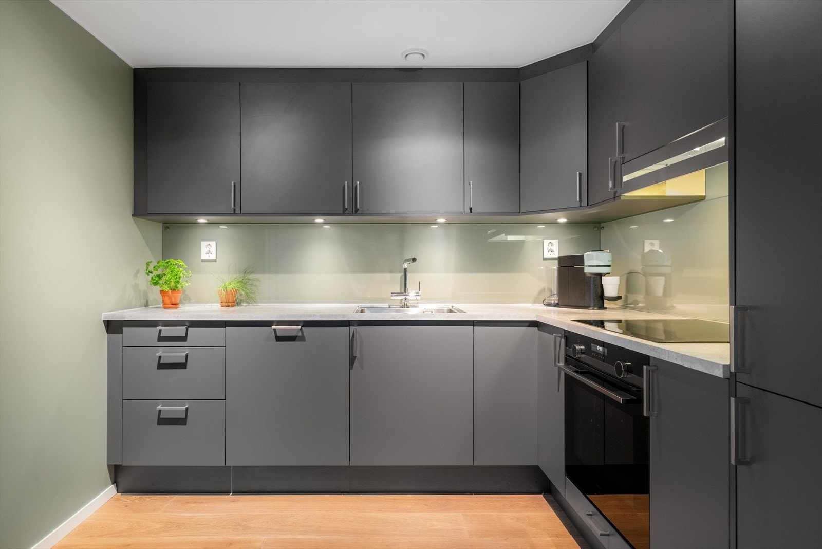 Benkeplaten i laminat har en planlimt kum og glassplate over benken. Galleribilde