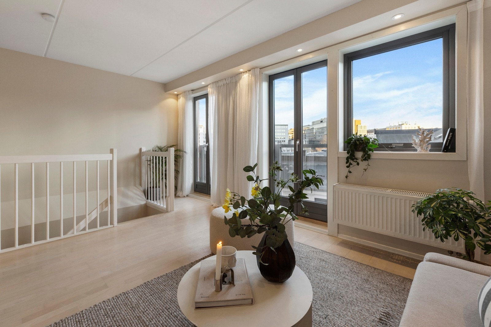 Store vindusflater gir rikelig med naturlig lys i leiligheten Galleribilde