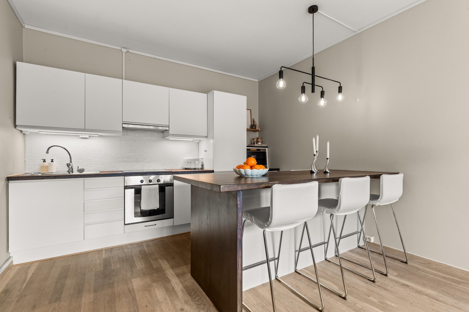 Kjøkkeninnredningen er tidløs og stilren med glatte fronter og heltre benkeplate med nedfelt vaskekum. Galleribilde