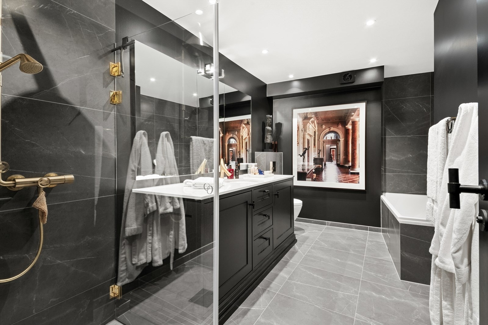 Badet har en moderne og luksuriøs utforming med store fliser i en naturlig steinlook som skaper en eksklusiv atmosfære. Baderommet var nytt i 2018. Galleribilde