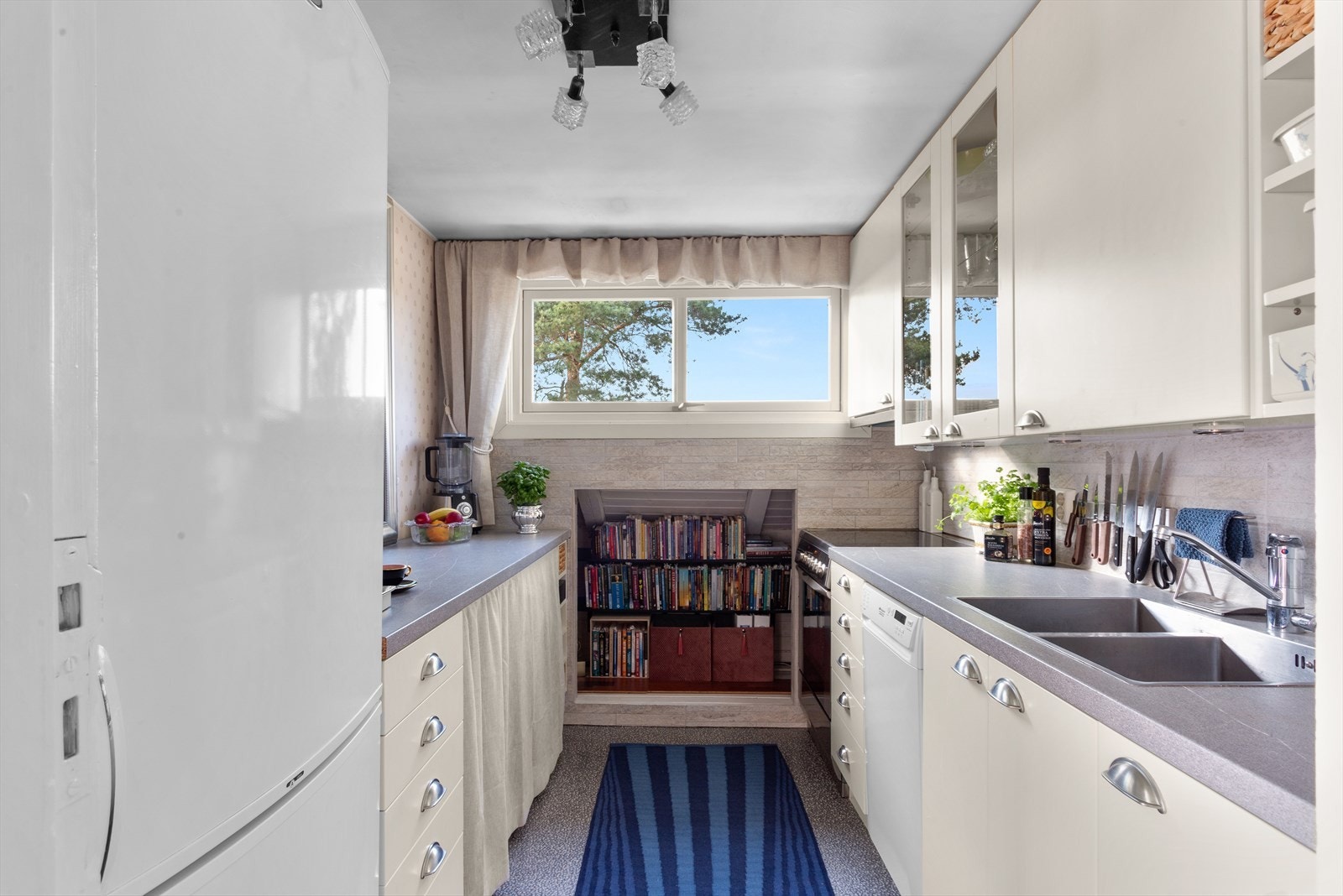 Det er montert downlights under overskapene, og veggen over benkeplaten er belagt med fliser. Galleribilde