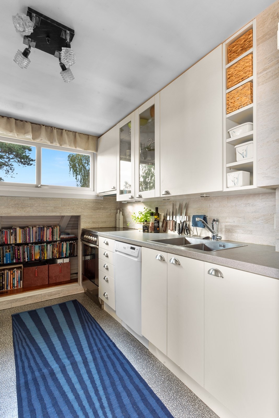 Kjøkkenet er utstyrt med komfyr og platetopp, vaskemaskin og smal oppvaskmaskin, samt frittstående kjøl-/fryseskap. Galleribilde