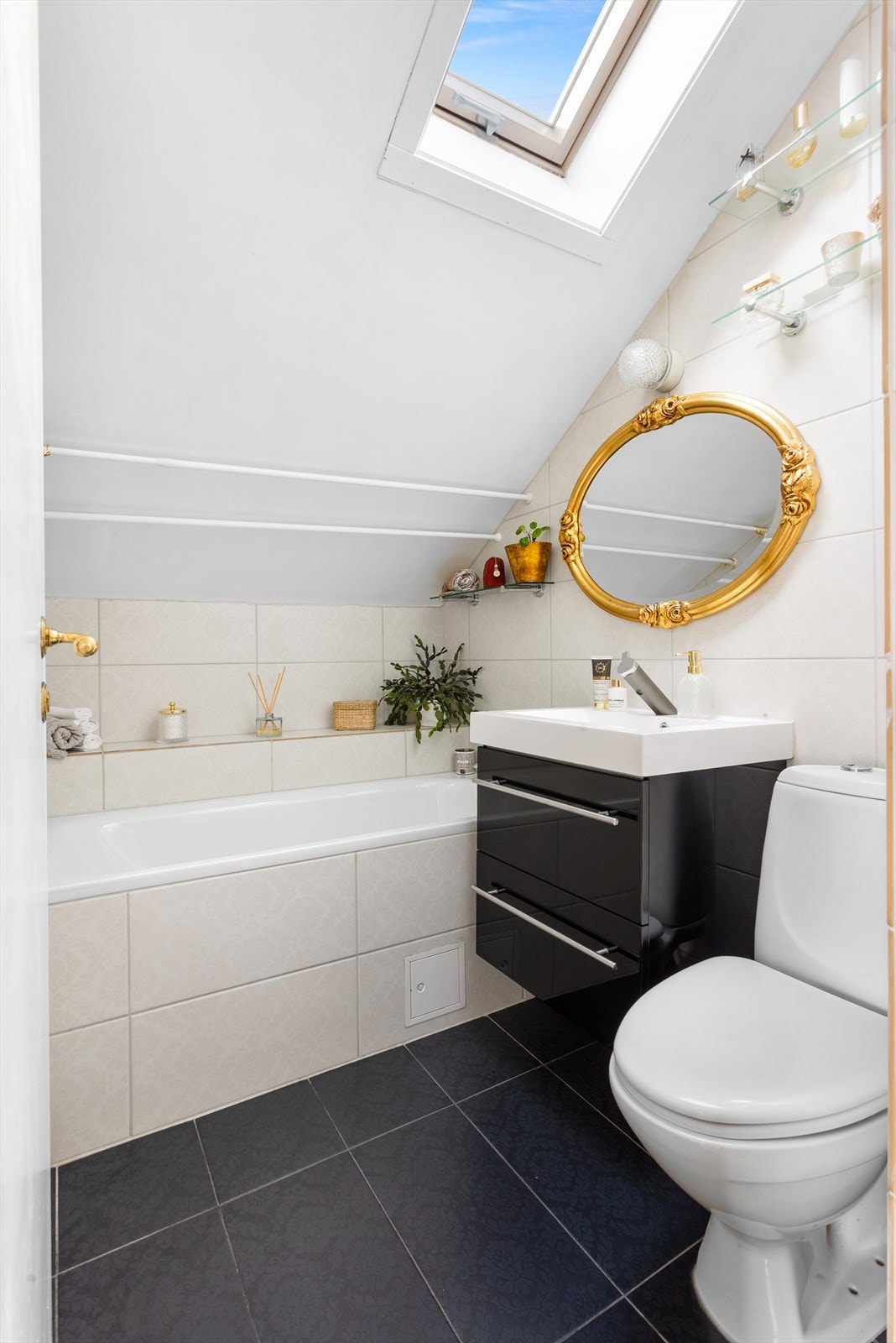 Badet har gulvmontert toalett og badekar med innfliset front og dusjutstyr. Galleribilde