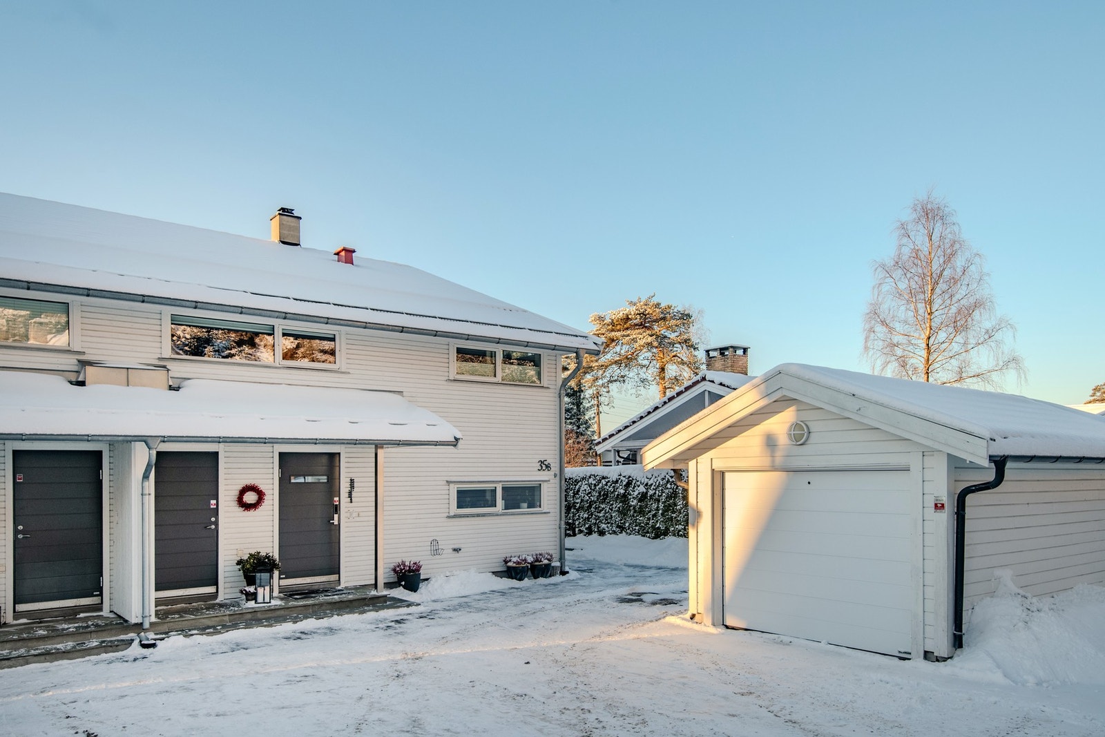 På gårdsplassen er det enkeltgarasje og flere p-plasser, ladeboks for elbil på yttervegg. Galleribilde