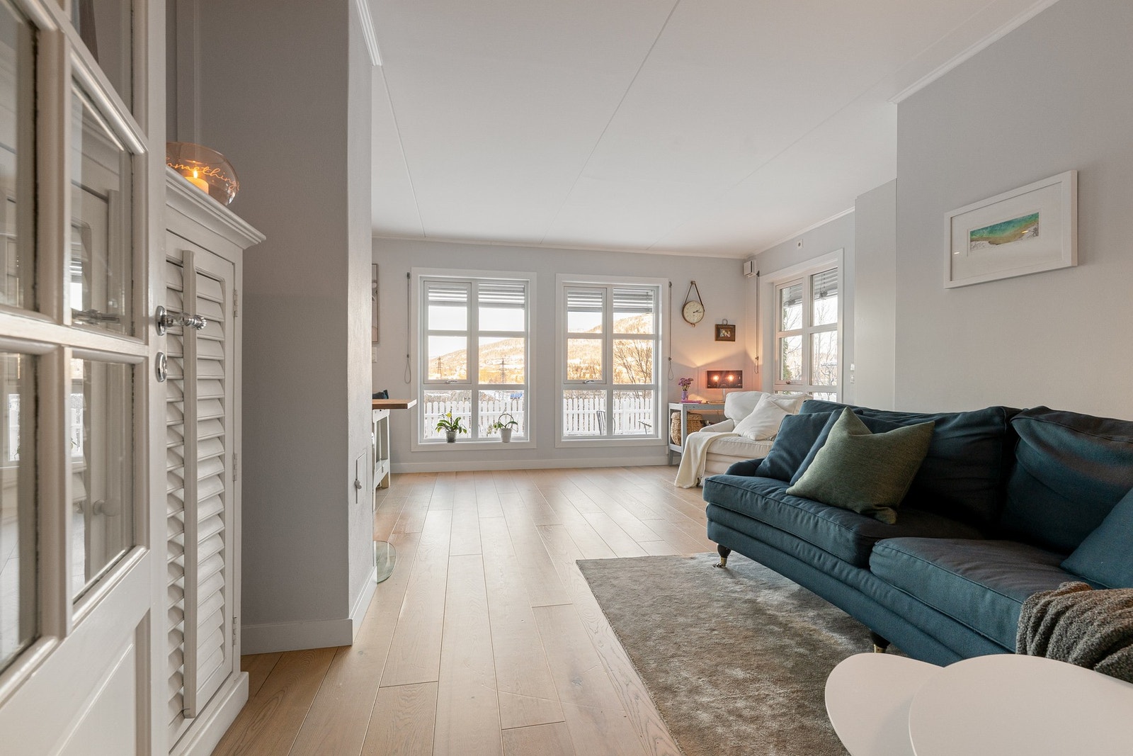 Romslig stue med utgang til overbygget terrasseplatting og hage med utsikt Galleribilde