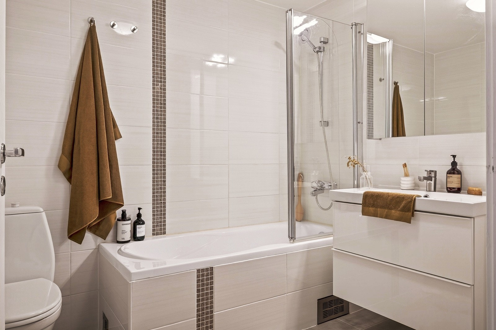 Badet måler ca. 5 kvm, og består av toalett, badekar med dusj, servant og speil med belysning. Galleribilde